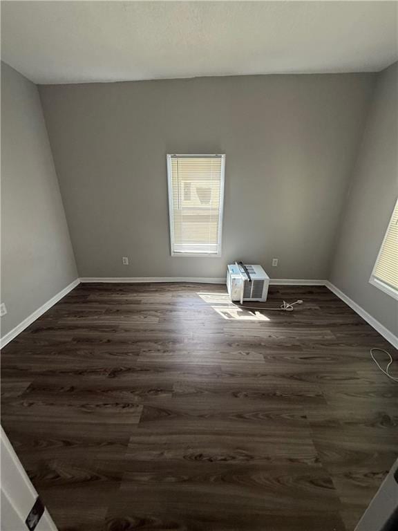 3318 E 24th St, Kansas City, MO 64127 - empty room with dark wood finished floors and baseboards