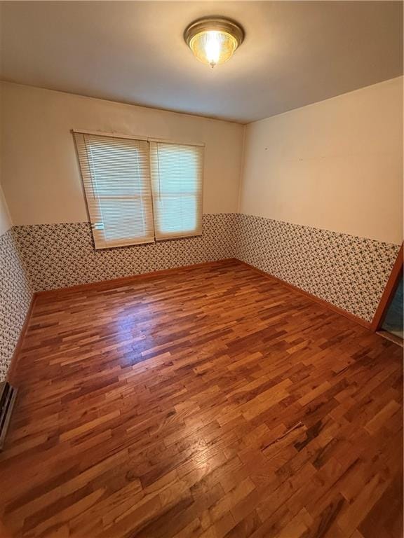 913 N Maple St, Stanberry, MO 64489 - spare room featuring wood finished floors and wainscoting