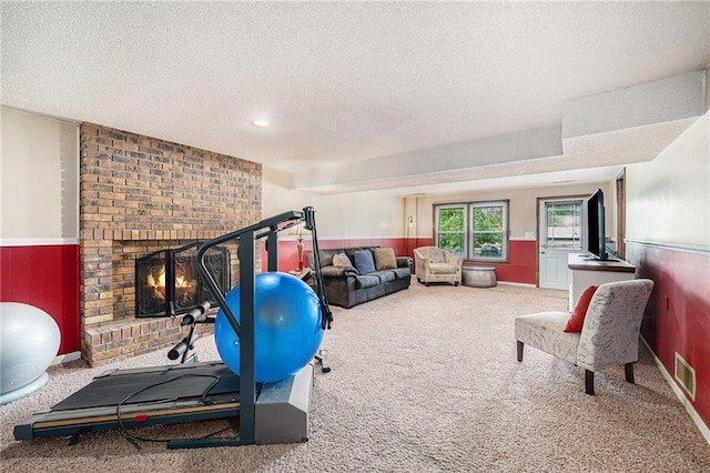 63 Maple Dr, Platte City, MO 64079 - workout area with carpet, a textured ceiling, a fireplace, and wainscoting
