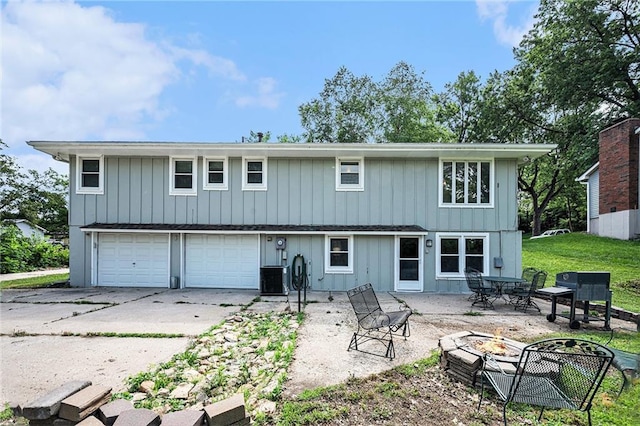 63 Maple Dr, Platte City, MO 64079 - rear view of property featuring an outdoor fire pit, a garage, driveway, and a patio area