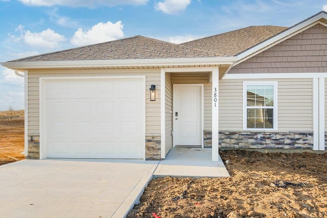 3818 NW 93rd St, Kansas City, MO 64154 - view of exterior entry with stone siding, driveway, and a garage