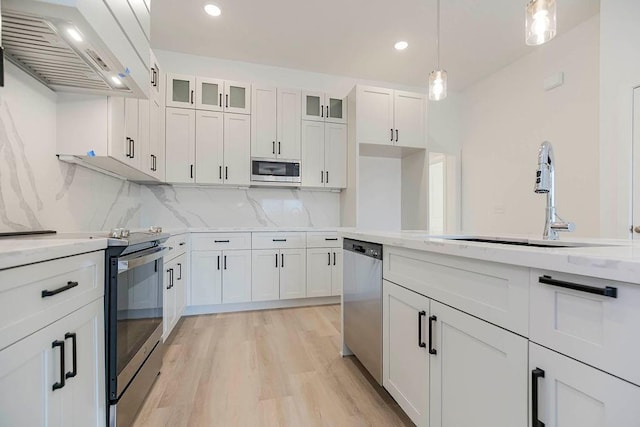 3818 NW 93rd St, Kansas City, MO 64154 - kitchen with extractor fan, appliances with stainless steel finishes, a sink, white cabinetry, and decorative backsplash