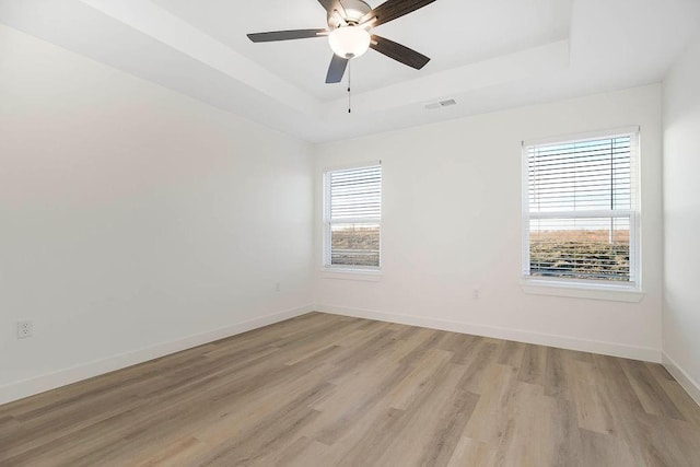 3818 NW 93rd St, Kansas City, MO 64154 - unfurnished room featuring a tray ceiling, light wood-style flooring, baseboards, and a ceiling fan