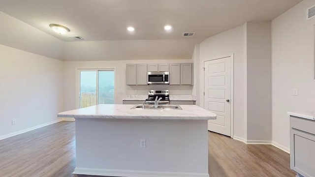551 W Lanesfield St, Gardner, KS 66030 - kitchen featuring stainless steel appliances, gray cabinets, a sink, light wood-style flooring, and lofted ceiling