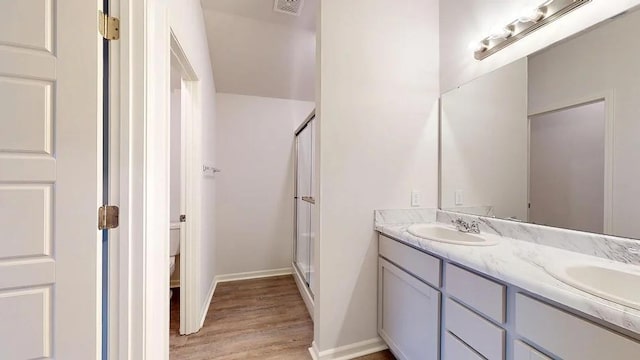 551 W Lanesfield St, Gardner, KS 66030 - full bath featuring double vanity, wood finished floors, a shower stall, baseboards, and toilet