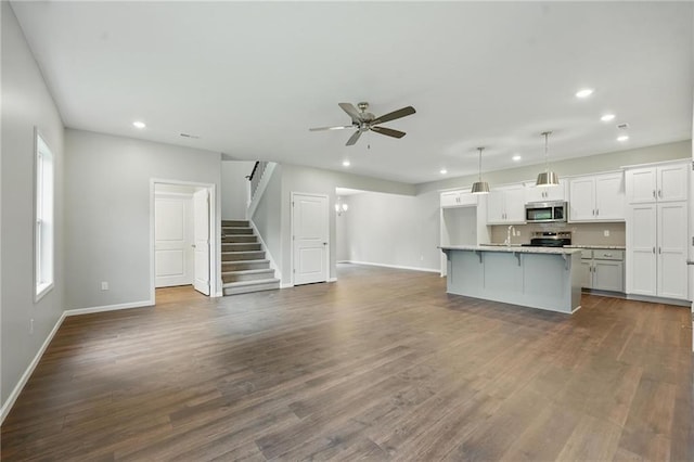 809 Highland Dr, Edwardsville, KS 66111 - unfurnished living room with recessed lighting, baseboards, a ceiling fan, dark wood-style floors, and stairs