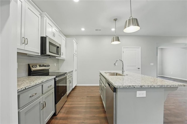 809 Highland Dr, Edwardsville, KS 66111 - kitchen featuring stainless steel appliances, a sink, an island with sink, baseboards, and light stone countertops