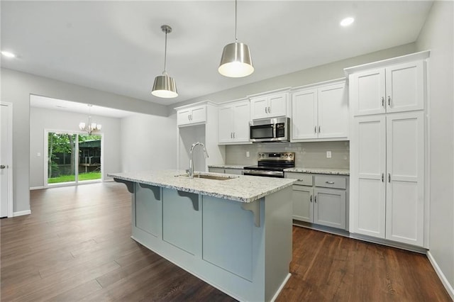 809 Highland Dr, Edwardsville, KS 66111 - kitchen with stainless steel appliances, a sink, a kitchen bar, dark wood-style flooring, and recessed lighting