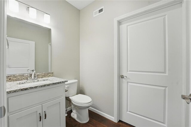 809 Highland Dr, Edwardsville, KS 66111 - bathroom featuring vanity, baseboards, wood finished floors, and toilet