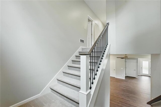 809 Highland Dr, Edwardsville, KS 66111 - stairway with ceiling fan, baseboards, wood finished floors, and a high ceiling