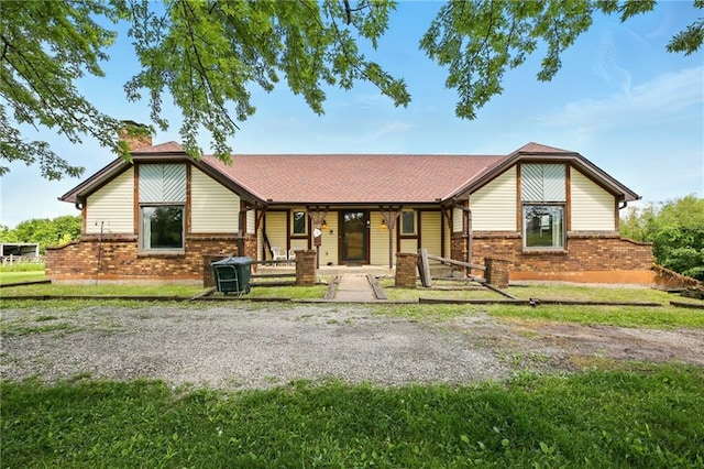 4613 SE Atchison Rd, Lathrop, MO 64465 - view of front facade with brick siding, a chimney, covered porch, and a front yard