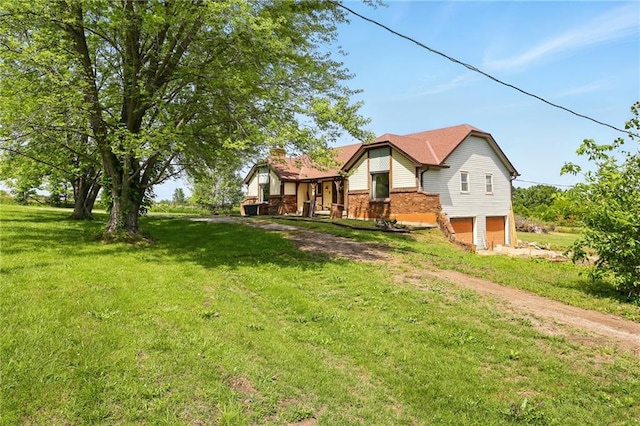 4613 SE Atchison Rd, Lathrop, MO 64465 - view of front of house with brick siding, a garage, a chimney, driveway, and a front lawn