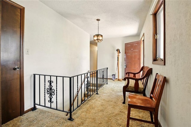 4613 SE Atchison Rd, Lathrop, MO 64465 - hallway featuring carpet floors, an upstairs landing, a textured ceiling, and baseboards