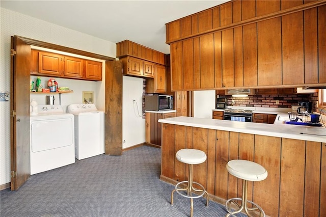 4613 SE Atchison Rd, Lathrop, MO 64465 - kitchen with washer and clothes dryer, dark colored carpet, brown cabinets, black microwave, and light countertops