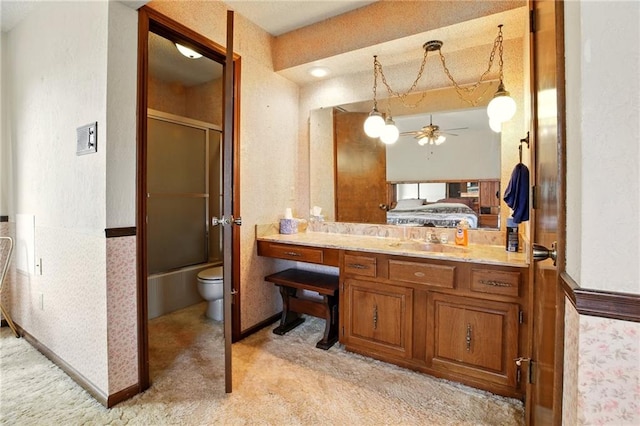 4613 SE Atchison Rd, Lathrop, MO 64465 - bathroom featuring a ceiling fan, connected bathroom, toilet, vanity, and enclosed tub / shower combo
