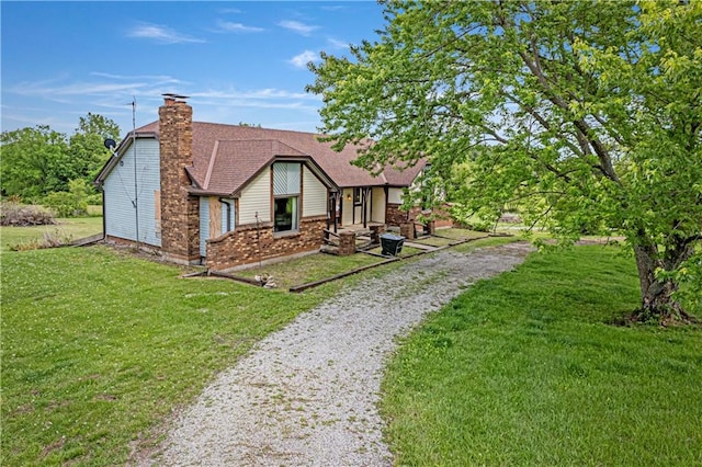4613 SE Atchison Rd, Lathrop, MO 64465 - view of front facade with a front yard, a chimney, and roof with shingles