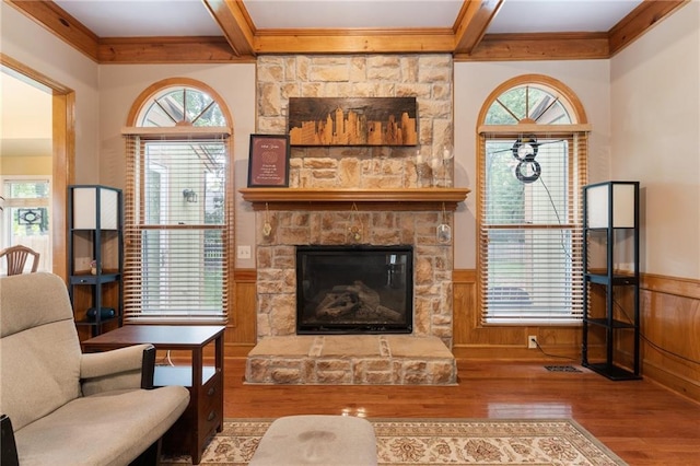 12484 S Hallet St, Olathe, KS 66062 - living room featuring wood finished floors, ornamental molding, wainscoting, a stone fireplace, and beam ceiling