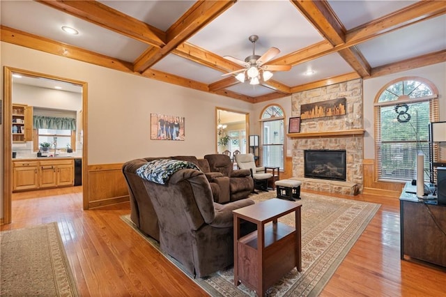 12484 S Hallet St, Olathe, KS 66062 - living area featuring beamed ceiling, light wood-style flooring, wainscoting, coffered ceiling, and a fireplace