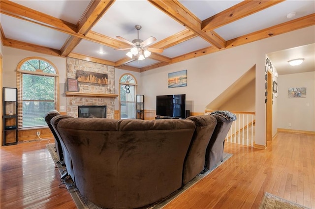 12484 S Hallet St, Olathe, KS 66062 - living room with ceiling fan, light wood-type flooring, coffered ceiling, a stone fireplace, and beamed ceiling
