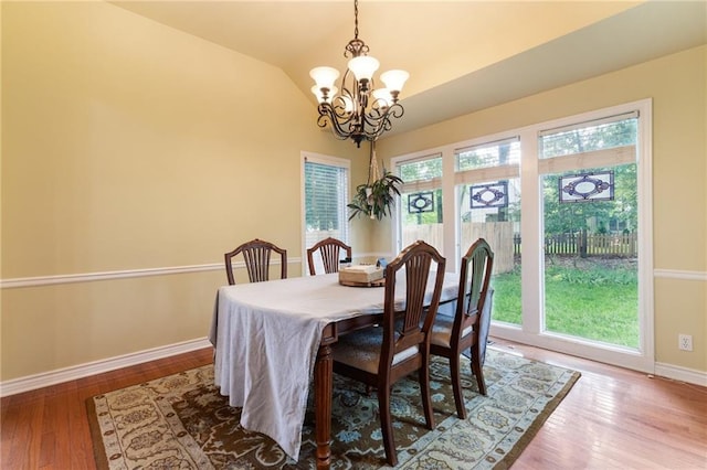 12484 S Hallet St, Olathe, KS 66062 - dining room featuring a chandelier, baseboards, wood finished floors, and lofted ceiling