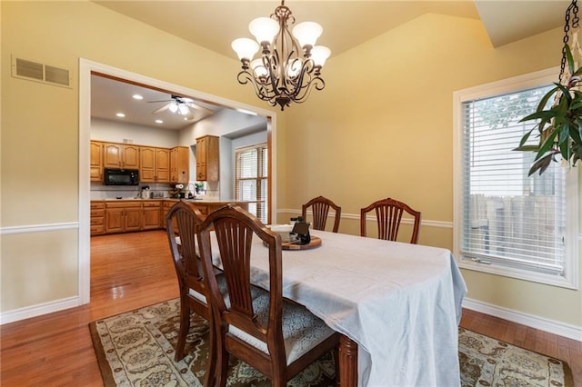 12484 S Hallet St, Olathe, KS 66062 - dining room featuring a chandelier, vaulted ceiling, light wood-style flooring, baseboards, and ceiling fan