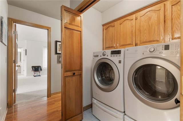 12484 S Hallet St, Olathe, KS 66062 - washroom featuring washing machine and dryer, light wood finished floors, and cabinet space
