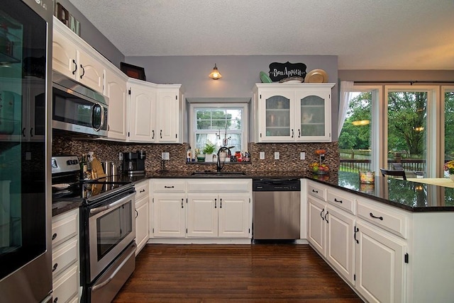 4737 Lone Elm St, Shawnee, KS 66226 - kitchen featuring appliances with stainless steel finishes, a sink, a peninsula, dark wood finished floors, and white cabinets