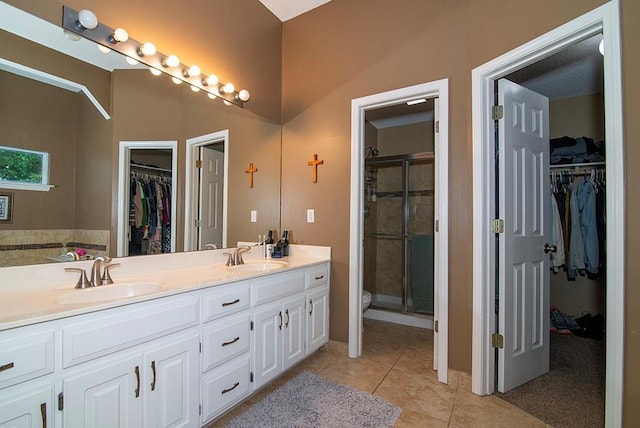 4737 Lone Elm St, Shawnee, KS 66226 - bathroom featuring double vanity, a walk in closet, a shower stall, tile patterned flooring, and toilet