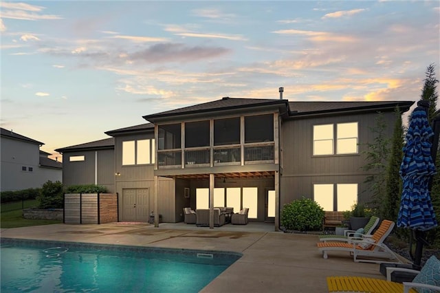 3112 Legacy Wood Dr, Lees Summit, MO 64086 - back of house at dusk featuring a patio, an outdoor hangout area, and an outdoor pool
