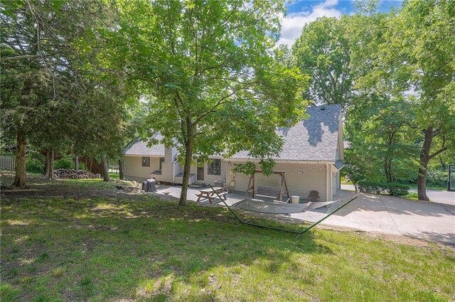21614 W 72nd St, Shawnee, KS 66218 - back of house with a patio area, a lawn, and a shingled roof