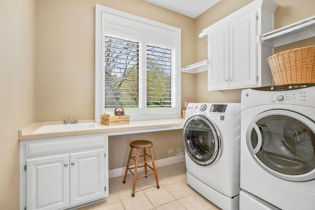 9705 Sunset Cir, Lenexa, KS 66220 - laundry area featuring washing machine and clothes dryer, cabinet space, light tile patterned flooring, and baseboards
