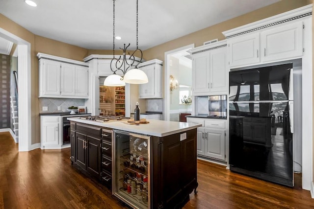 9705 Sunset Cir, Lenexa, KS 66220 - kitchen with freestanding refrigerator, stainless steel gas stovetop, a kitchen island with sink, recessed lighting, and beverage cooler