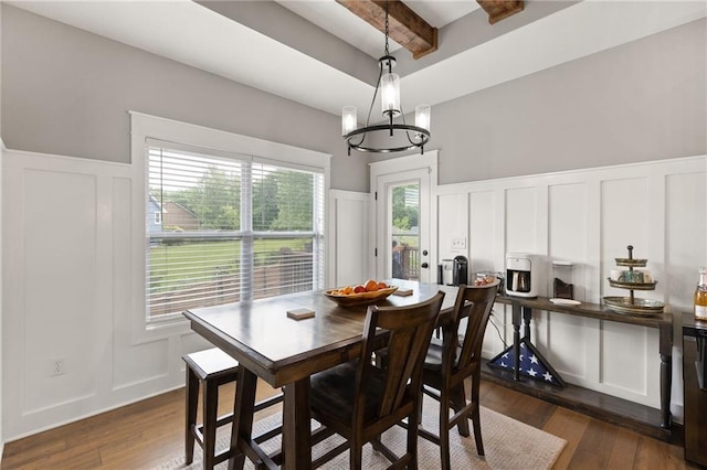 481 Olive Ct, Warrensburg, MO 64093 - dining area with a decorative wall, beam ceiling, a chandelier, dark wood-type flooring, and a wainscoted wall
