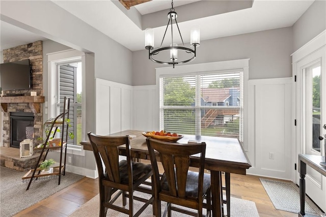 481 Olive Ct, Warrensburg, MO 64093 - dining room with a decorative wall, light wood-style flooring, a chandelier, wainscoting, and a tray ceiling