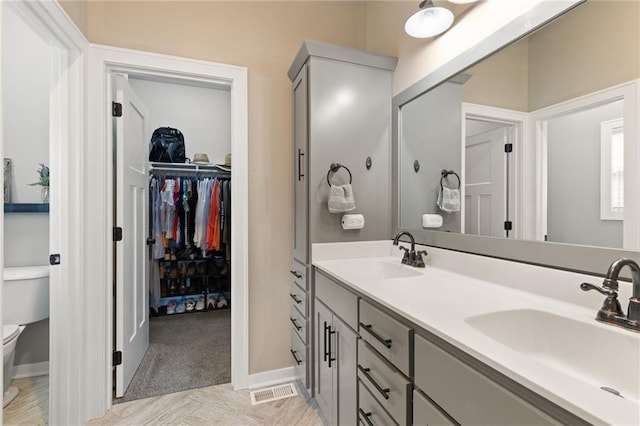 481 Olive Ct, Warrensburg, MO 64093 - full bathroom featuring toilet, double vanity, a spacious closet, and baseboards