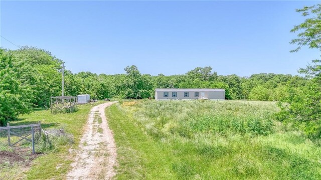 614 SW T Hwy, Holden, MO 64040 - view of yard with a wooded view and dirt driveway