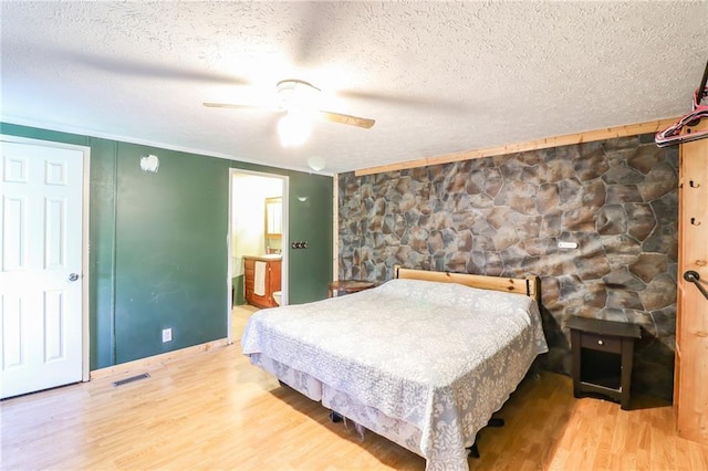 614 SW T Hwy, Holden, MO 64040 - bedroom featuring wood finished floors, a textured ceiling, ensuite bath, ceiling fan, and ornamental molding