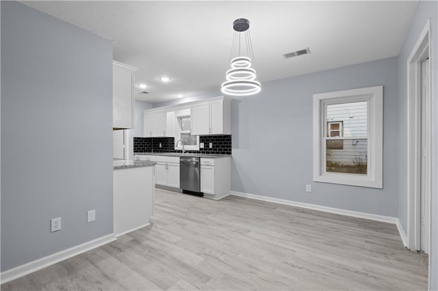 1709 Marty Ave, Kansas City, KS 66103 - kitchen with stainless steel dishwasher, decorative backsplash, light wood-style flooring, white cabinets, and baseboards