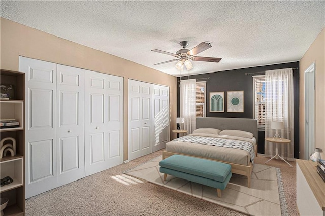 8564 W 85th St, Overland Park, KS 66212 - carpeted bedroom featuring two closets, a textured ceiling, and ceiling fan