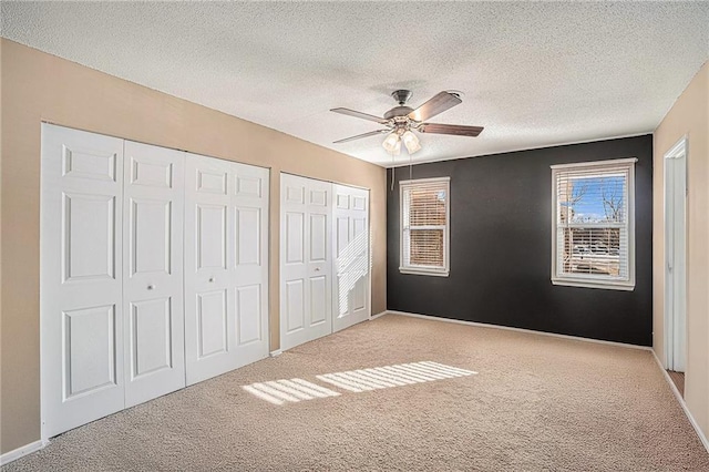 8564 W 85th St, Overland Park, KS 66212 - unfurnished bedroom with carpet flooring, two closets, a textured ceiling, and ceiling fan