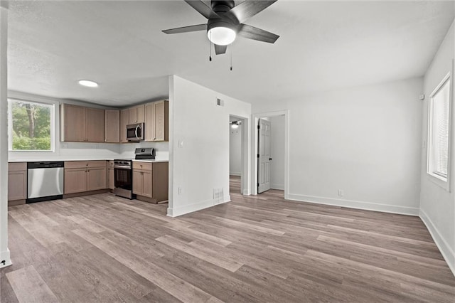 6 W 98th Ter, Kansas City, MO 64114 - kitchen with appliances with stainless steel finishes, light countertops, light wood-style flooring, baseboards, and a ceiling fan