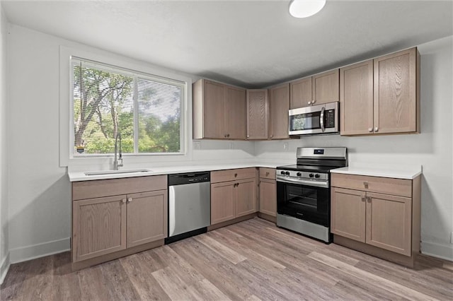 6 W 98th Ter, Kansas City, MO 64114 - kitchen with appliances with stainless steel finishes, a sink, light wood-style flooring, and baseboards