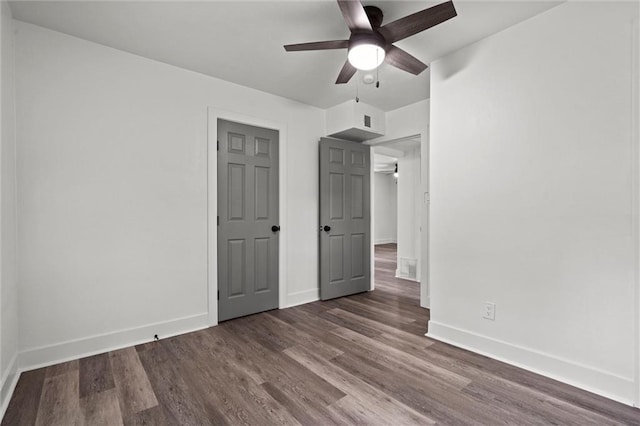 6 W 98th Ter, Kansas City, MO 64114 - unfurnished bedroom featuring baseboards, wood finished floors, and ceiling fan
