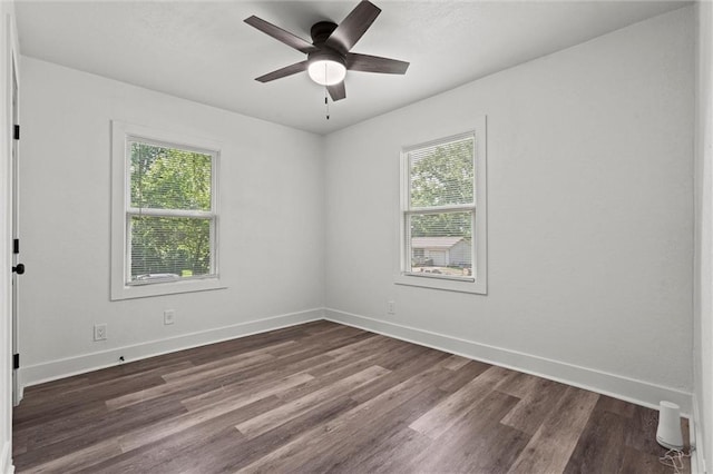 6 W 98th Ter, Kansas City, MO 64114 - spare room featuring healthy amount of natural light, dark wood-type flooring, a ceiling fan, and baseboards
