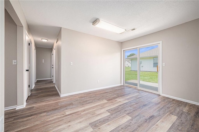 214 NW Parker Dr, Grain Valley, MO 64029 - spare room featuring wood finished floors, a textured ceiling, and baseboards