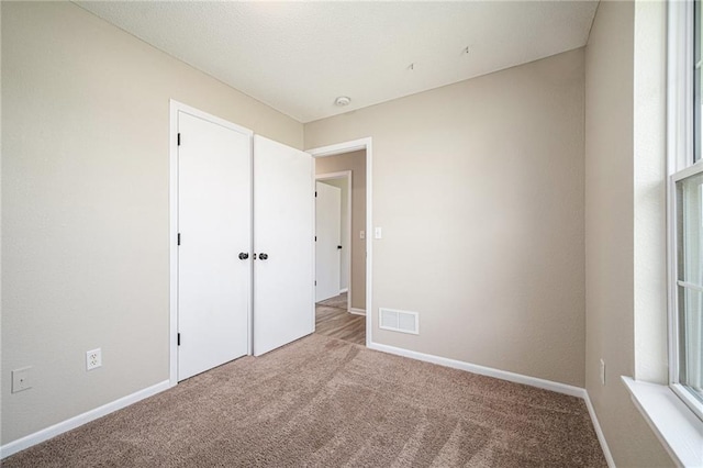 214 NW Parker Dr, Grain Valley, MO 64029 - unfurnished bedroom featuring carpet, baseboards, and a closet