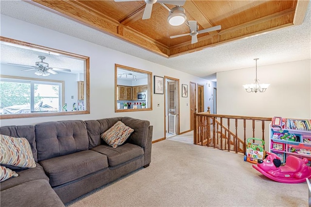 516 S St, Grain Valley, MO 64029 - carpeted living room featuring a ceiling fan, a chandelier, and wooden ceiling