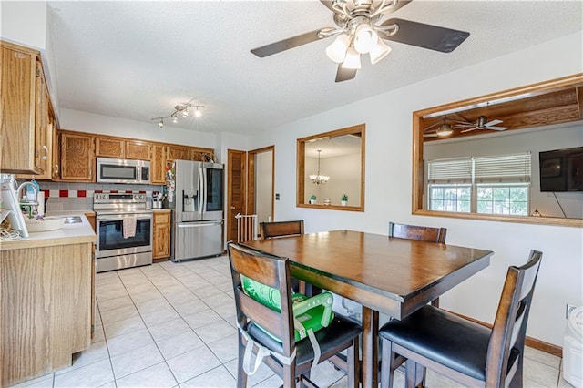 516 S St, Grain Valley, MO 64029 - dining space with light tile patterned floors, a ceiling fan, and a textured ceiling
