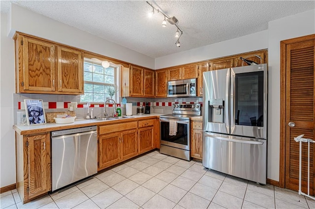 516 S St, Grain Valley, MO 64029 - kitchen with appliances with stainless steel finishes, light countertops, brown cabinets, backsplash, and a textured ceiling