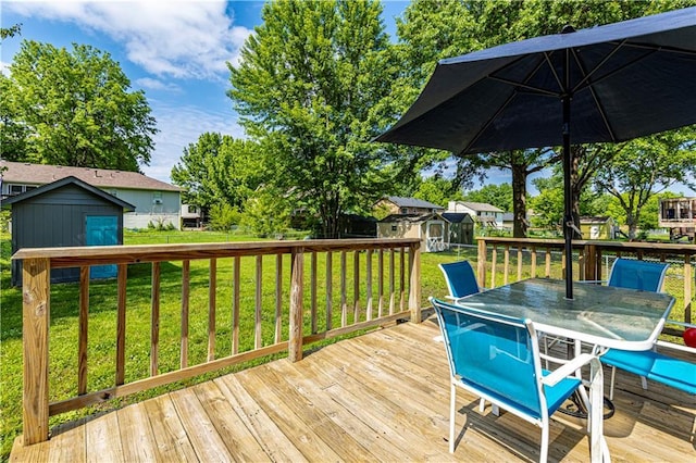 516 S St, Grain Valley, MO 64029 - deck with a storage shed, outdoor dining space, and a lawn